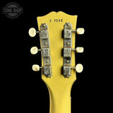 Close-up of a guitar headstock with tuning pegs on a black background, featuring 'Tone Shop' branding.
