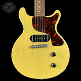 Yellow electric guitar with a flame maple neck on a black background, featuring the Tone Shop logo.