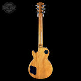 Back view of a wooden electric guitar with 'Tone Shop' logo in the corner.