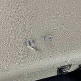 Textured beige surface with two water droplets and a metal clip.
