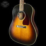 Acoustic guitar with a sunburst finish on a black background, featuring the Tone Shop logo.