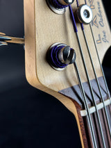 Close-up of a guitar's bridge and tuning pegs on a dark background