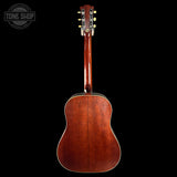 Back view of a wooden acoustic guitar on a black background with 'Tone Shop' logo.