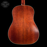 Back view of a wooden acoustic guitar with 'Tone Shop' logo.