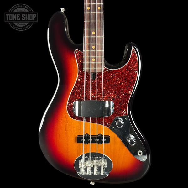 Electric bass guitar with a sunburst finish on a black background, featuring the Tone Shop logo.