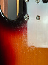 Close-up of a guitar's neck with a sunburst finish and visible screws.