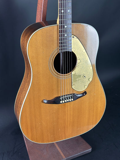 Acoustic guitar with a wooden body and neck on a dark background