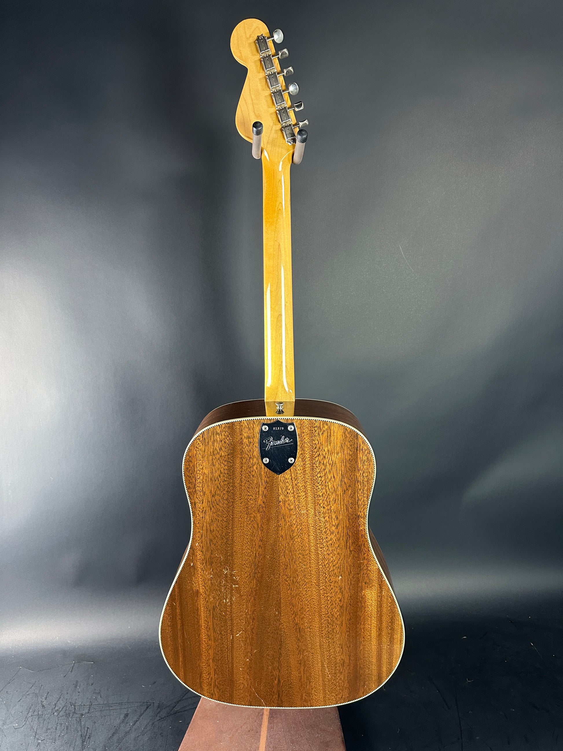 Wooden acoustic guitar on a gray background
