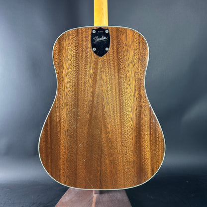 Wooden acoustic guitar with Fender logo on a dark gray background
