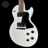 A white electric guitar with a black pickguard and black hardware, shown against a solid black background. A Tone Shop logo watermark is visible in the top-left corner.