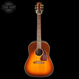 Acoustic guitar with a sunburst finish on a black background, featuring the Tone Shop logo.