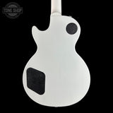 The back of a white electric guitar, showing the body contour, black pickups, and neck joint against a solid black background.