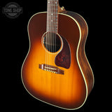 Acoustic guitar with a sunburst finish on a black background, featuring the Tone Shop logo.