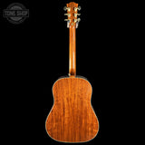 Back view of a wooden acoustic guitar with 'Tone Shop' logo in the corner.
