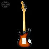 A classic electric guitar shown from the back, featuring a sunburst finish that transitions from bright yellow-orange to dark black, with a white pickguard and maple neck, set against a solid black background.