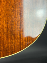 Close-up of a guitar's wooden soundboard with a metal edge.