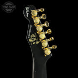 Guitar headstock with gold tuning pegs on a black background, featuring 'Tone Shop' branding.