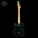 A black electric guitar shown from the back, featuring a glossy black body, maple neck, and gold-toned hardware, photographed against a solid black background with a Tone Shop watermark in the top-left corner.