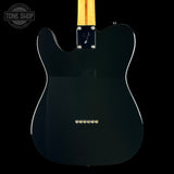 The back of a black Fender Telecaster electric guitar, featuring a glossy black finish, gold hardware, and a light wood neck visible at the top, set against a solid black background.