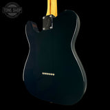 The back of a Fender Telecaster electric guitar in glossy black, featuring a maple neck and gold hardware, shown against a solid black background with a Tone Shop watermark in the top left corner.