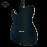 Black electric guitar with gold tuning pegs on a black background, featuring 'Tone Shop' logo.