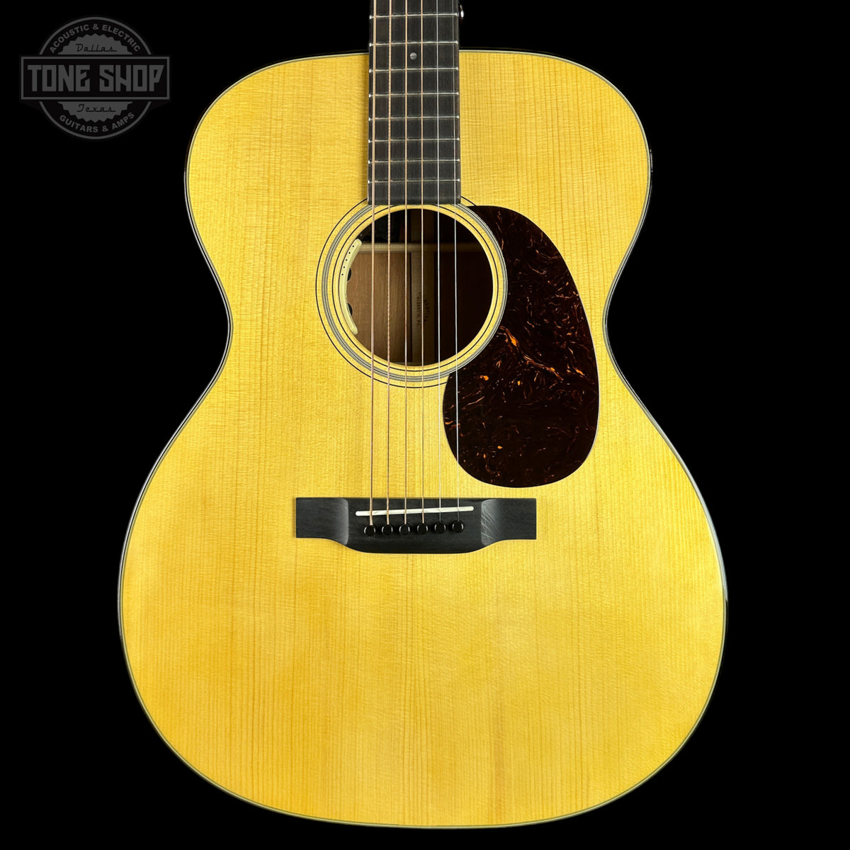 Acoustic guitar with a visible brand logo on a black background