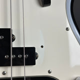Close-up detail of a white electric bass guitar body, showing black hardware, silver screws, and part of the pickguard.