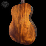 Close-up of a wooden acoustic guitar body with 'Tone Shop' logo.