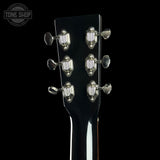 Close-up of a guitar headstock with tuning pegs on a black background, featuring the Tone Shop logo.