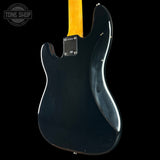 Rear view of a black electric guitar body with a yellow maple neck, photographed against a solid black background. A Tone Shop watermark is visible in the top-left corner.