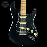 A black electric guitar with a maple neck, cream pickups, and chrome hardware, shown against a solid black background with a Tone Shop watermark in the top left corner.