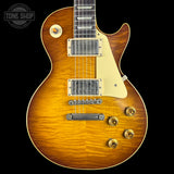 A classic electric guitar with a natural sunburst finish, featuring a cream pickguard, dual humbucker pickups, and gold-toned hardware, shown against a solid black background.