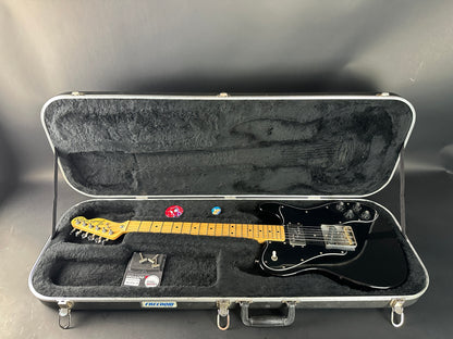 Guitar in a hard-shell case on a gray background