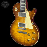 A classic electric guitar with a natural sunburst finish, cream pickguard, and gold hardware, shown against a solid black background with a Tone Shop watermark in the top left corner.