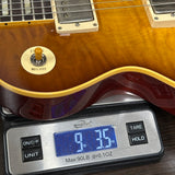 Close-up of a sunburst electric guitar body resting on a digital scale showing 9 lbs 3.5 oz, with the guitar's tremolo system and pickups visible.
