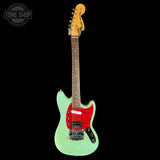 Electric guitar with a green body and red pickguard on a black background, featuring 'Tone Shop' logo.
