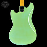 Green electric guitar body with a visible brand logo on a black background