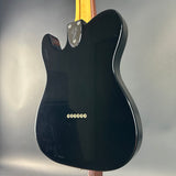 Black electric guitar body with Fender logo on a gray background