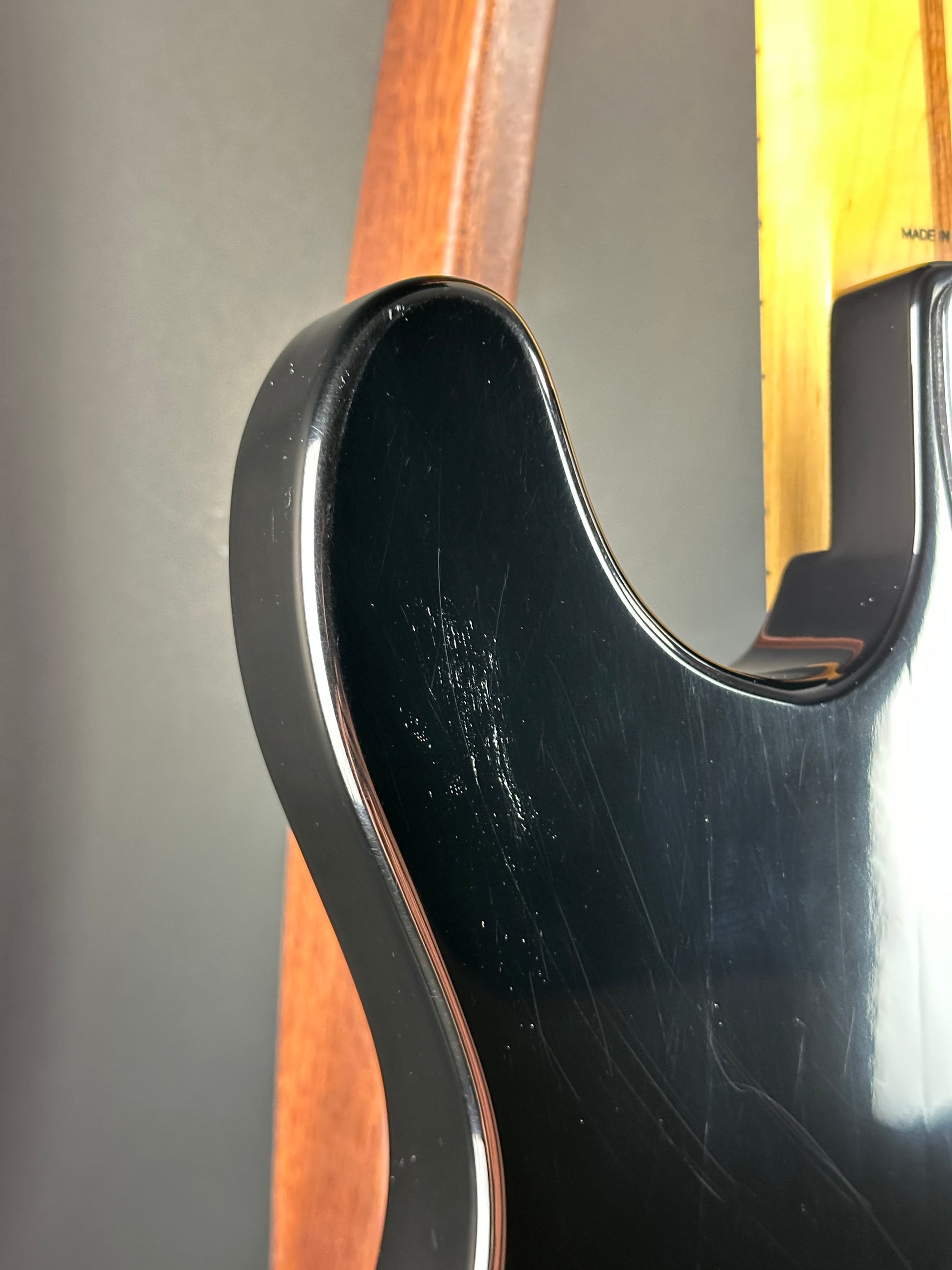 Close-up of a guitar's neck and headstock with a black pickguard.