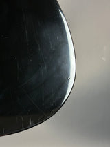 Close-up of a black object with visible scratches on a gray background