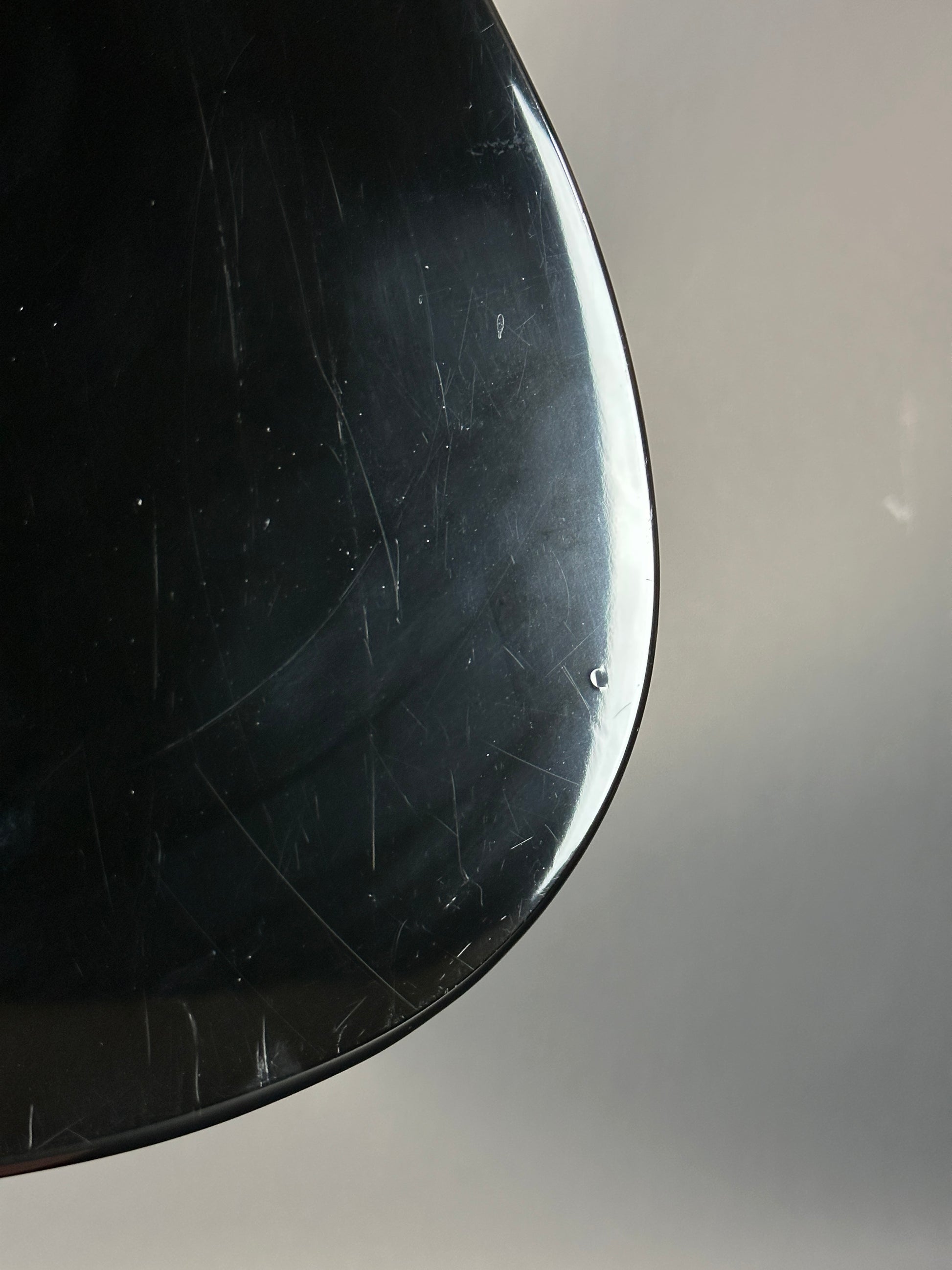 Close-up of a black object with visible scratches on a gray background