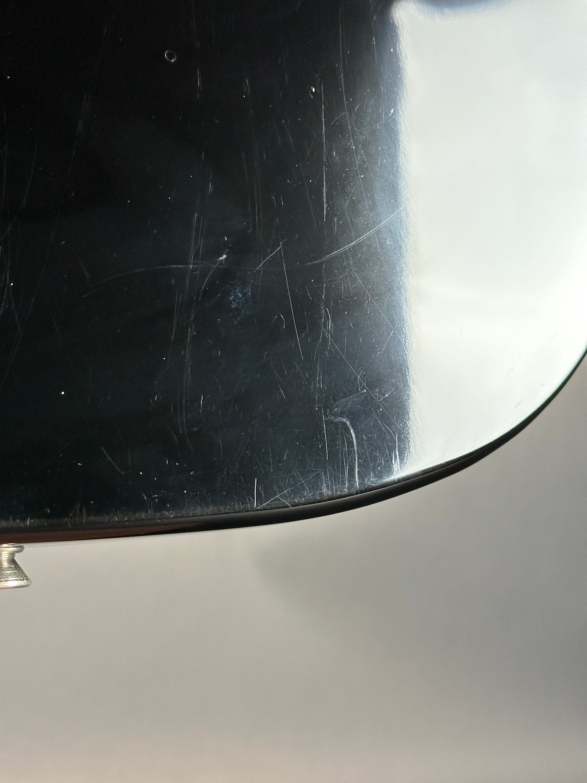 Scratched black surface with a metallic edge on a gray background