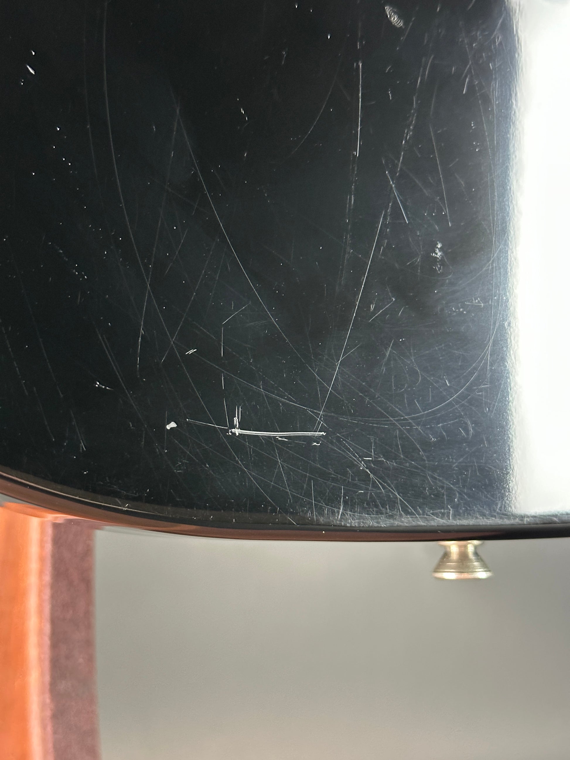 Scratched black surface with a gold handle on a gray background