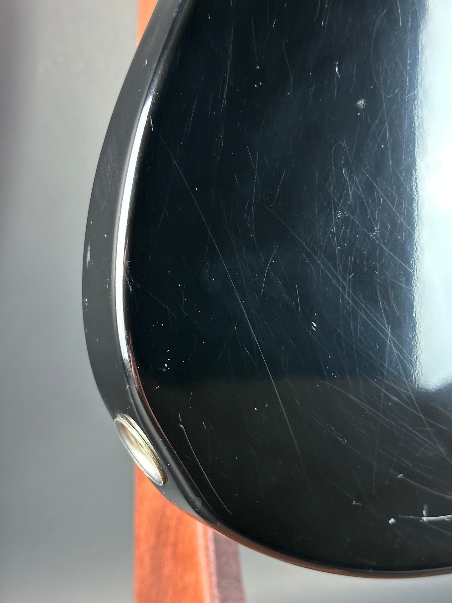 Scratched black surface with a metallic button on a blurred background