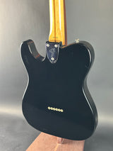 Black electric guitar body on a gray background