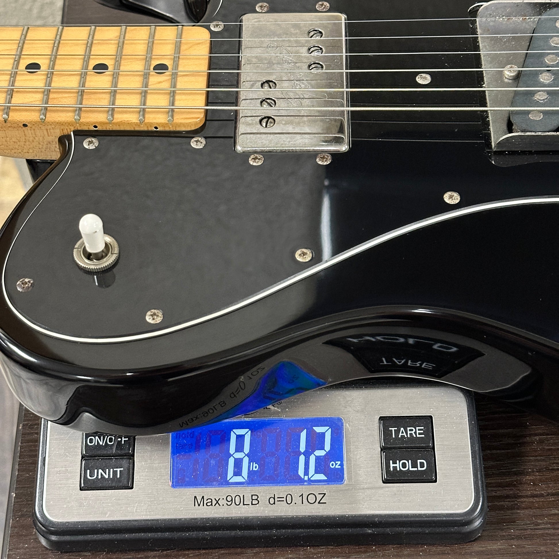 Used 1980s Fender MIJ Telecaster HS Black on a scale displaying weight.