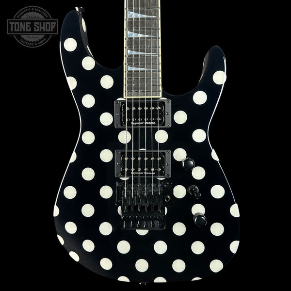 A black electric guitar with a bold white polka-dot pattern, shown from the front against a solid black background. The brand 'Tone Shop' is visible as a watermark in the top-left corner.