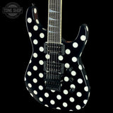 A black electric guitar with a bold white polka dot pattern, shown against a solid black background. The brand 'Tone Shop' is visible as an overlay in the top-left corner.