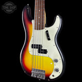 A classic Bass electric guitar with a sunburst finish, featuring a white pickguard and black hardware, shown against a solid black background with a Tone Shop watermark in the top left corner.