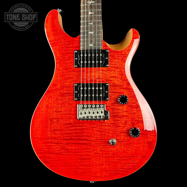 Red electric guitar with a black background, featuring the Tone Shop logo.